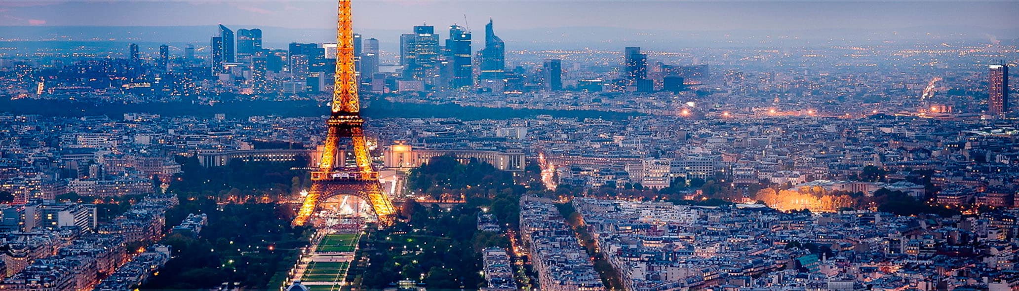 Vista panorámica de París al atardecer con la Torre Eiffel iluminada